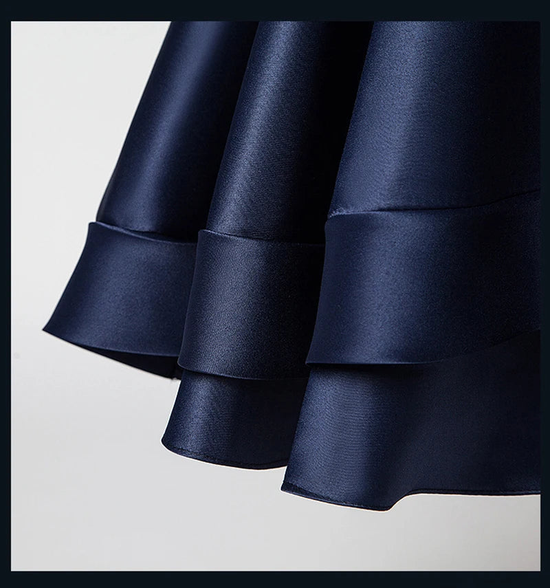 Navy blue satin fabric with ruffled layers on a light gray background