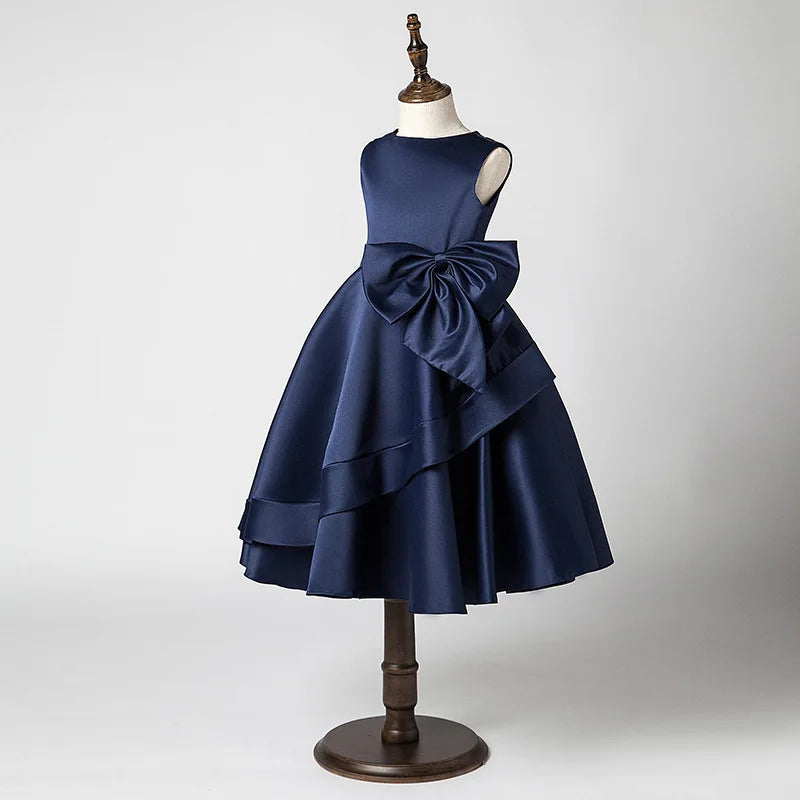 Navy blue dress with a large bow on a mannequin against a gray background