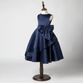 Navy blue dress with a large bow on a mannequin against a gray background