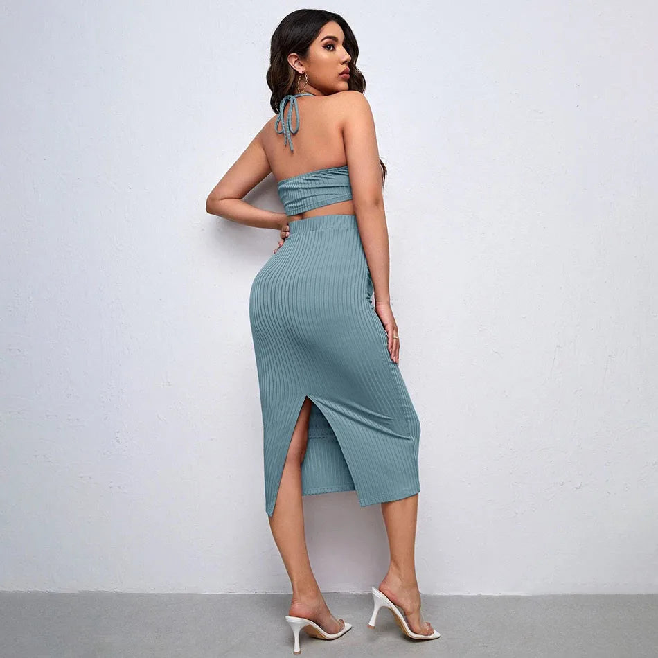 Woman wearing a teal ribbed two-piece outfit against a plain background