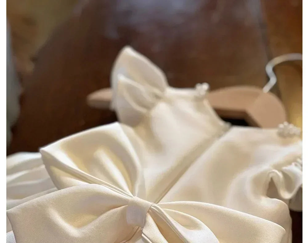 Close-up of a cream-colored satin bow with a blurred background