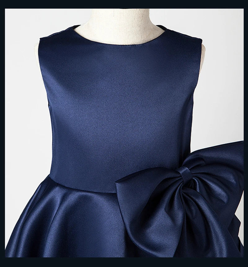 Navy blue dress with a large bow on a mannequin against a white background