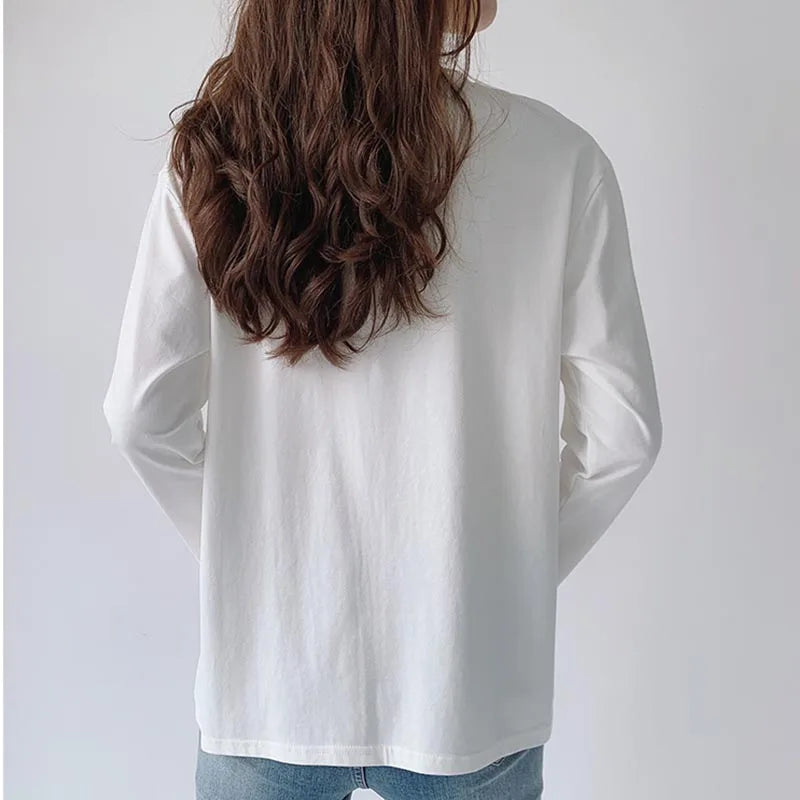 Person wearing a white long-sleeve shirt from behind on a plain background